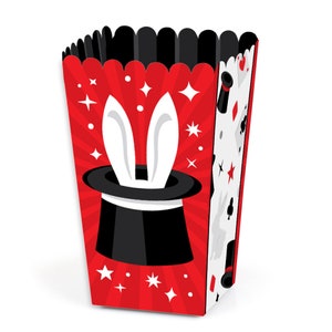 May include: Red and white popcorn box with a black and white illustration of a magic hat with bunny ears and stars. The box is decorated with a red and white striped pattern.
