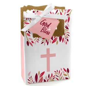 May include: White favor bag with a pink cross and floral border. The bag has a pink tag attached with the text "God Bless".