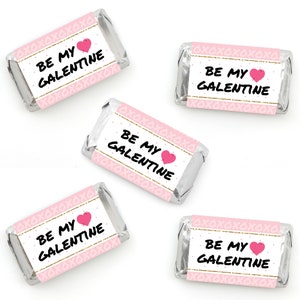 May include: Five pink and gold mini chocolate bar wrappers with the text "Be My Galentine" and a pink heart.