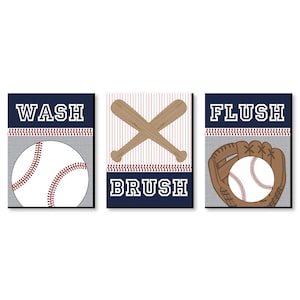 May include: Three bathroom signs with a baseball theme. The first sign says "WASH" and has a baseball. The second sign says "BRUSH" and has two crossed baseball bats. The third sign says "FLUSH" and has a baseball glove with a baseball inside.