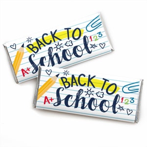 May include: Two rectangular candy bar wrappers featuring a white background with blue horizontal lines resembling notebook paper. The design includes the text "BACK TO School" in blue, a yellow pencil, a blue paperclip, red "A+" text, and small doodles of hearts, stars, and suns.