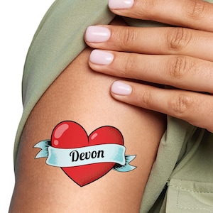 May include: A temporary tattoo with a red heart and a blue banner that says "Devon".