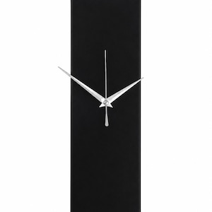 Pode incluir: Um relógio de parede retangular com um mostrador preto fosco sólido. O relógio apresenta três ponteiros finos de metal prateado posicionados no centro. O design é limpo e vertical, sem números ou marcadores de hora no mostrador.