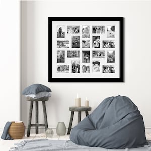May include: A black framed photo collage with 20 black and white images hangs on a white wall. The photos show people and scenes. A grey beanbag chair, two wooden stools, and a woven basket are in the foreground. The room has a neutral colour scheme.