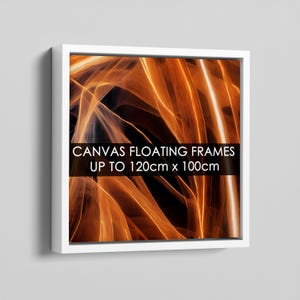 May include: A square white floating frame containing a canvas print with abstract orange and black light streaks. A black horizontal band across the centre displays the white text: CANVAS FLOATING FRAMES UP TO 120cm x 100cm.