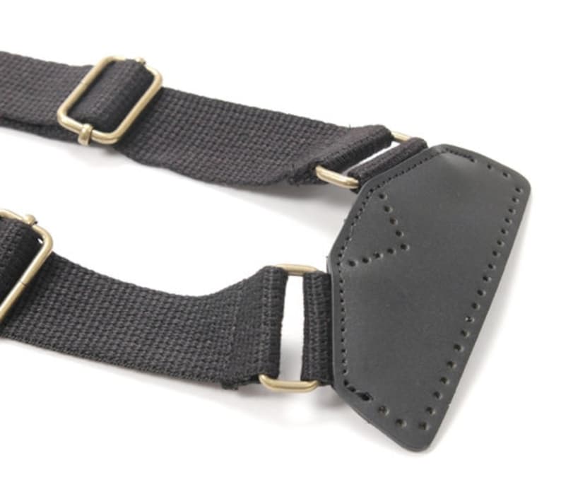 May include: Black canvas strap with two gold metal buckles and a black leather patch with stitching.