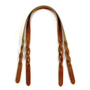 May include: A set of three brown leather braided handles. The handles are approximately 12 inches long and have a braided design.