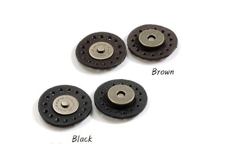 May include: Two sets of leather snap closures, one in black and one in brown. Each set features a round metal snap with a decorative ring around the edge.