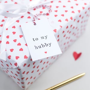 May include: A white gift box with a red heart pattern and a white gift tag that says "to my hubby".