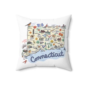 May include: A white square throw pillow featuring a colorful illustrated map of Connecticut. The design includes various landmarks, city names, trees, a bird, and a lobster, with the word Connecticut written in large blue script at the bottom.