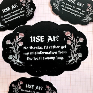 May include: Black stickers with the text "USE AI?" and "No thanks. I'd rather get my misinformation from the local swamp hag." The stickers have a cloud shape with floral and star designs in white and pink.