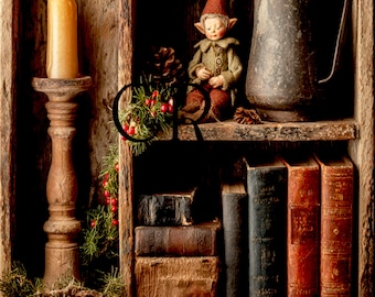 May include: A wooden shelf unit containing a tall candle on a wooden holder, a small elf figurine with a red hat, a dark metal pitcher, and several old books. A decorative garland of green pine needles and red berries hangs down the side.