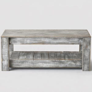 May include: A rectangular, weathered-look coffee table with a lower shelf. The table is constructed of gray-painted wood with visible grain and a distressed finish. The design features a simple, open-frame construction.