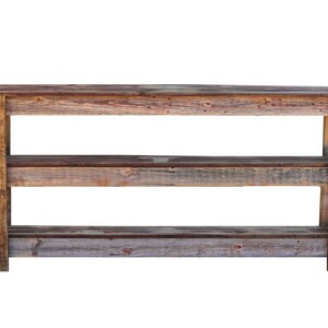 Puede incluir: Una mesa consola de madera r&uacute;stica con tres estantes. La mesa est&aacute; hecha de madera reciclada y tiene un acabado natural.