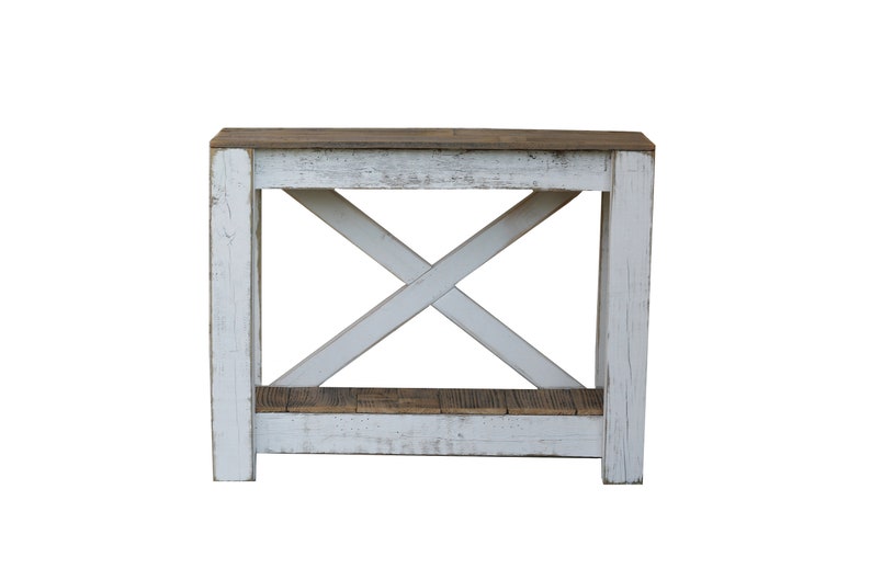 May include: Whitewashed wooden console table with a distressed finish. The table has a single shelf and an X-shaped support structure.