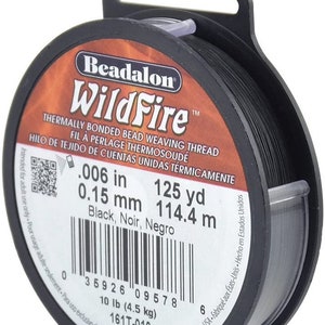 以下が含まれることがあります： 黒色のビーズロンワイルドファイア熱結合ビーズ織り糸のスプール。スプールには、糸のサイズ（0.006インチまたは0.15ミリメートル）と長さ（125ヤードまたは114.4メートル）が記載されています。スプールには、重量（10ポンドまたは4.5キログラム）と製品番号（161T-010）も記載されています。