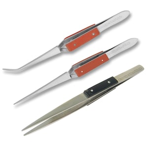 Puede incluir: Tres pares de pinzas de acero inoxidable con diferentes estilos de puntas. Los dos pares superiores tienen mangos rojos con el texto "Prestige Hand Tools" impreso en ellos. El par inferior tiene un mango negro con el mismo texto impreso en él.