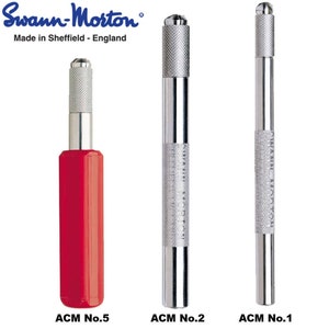 Puede incluir: Tres herramientas de metal con mangos de diferentes tamaños. La herramienta de la izquierda tiene un mango rojo y está etiquetada como "ACM No.5". La herramienta del medio es plateada y está etiquetada como "ACM No.2". La herramienta de la derecha también es plateada y está etiquetada como "ACM No.1".