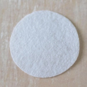 May include: A white round felt circle.