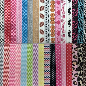 Op de afbeelding: Een verzameling kleurrijke haarbandjes met verschillende patronen, waaronder geometrische, dierenprint en sportthema's. De haarbandjes zijn in twee rijen gerangschikt.