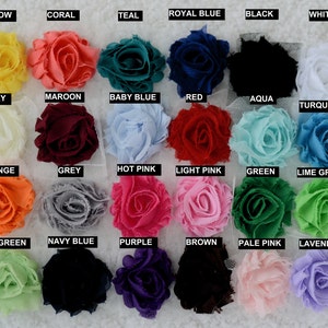 May include: A color chart of 24 fabric flower embellishments. The flowers are arranged in four rows of six flowers each. The flowers are in a variety of colors, including yellow, coral, teal, royal blue, black, white, ivory, maroon, baby blue, red, aqua, turquoise, orange, grey, hot pink, light pink, green, lime green, mint green, navy blue, purple, brown, pale pink, and lavender.