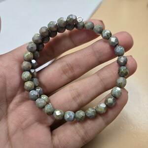 May include: A green and blue faceted glass bead bracelet with a silver clasp.