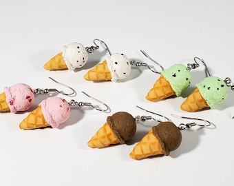 May include: Six pairs of ice cream cone earrings. The earrings are made of polymer clay and feature different flavors of ice cream, including chocolate, strawberry, mint chip, and vanilla. The earrings are a fun and whimsical accessory for any ice cream lover.