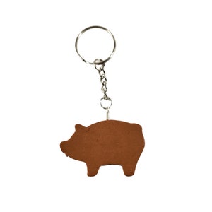 May include: A brown pig-shaped keyring with a silver metal ring and chain.