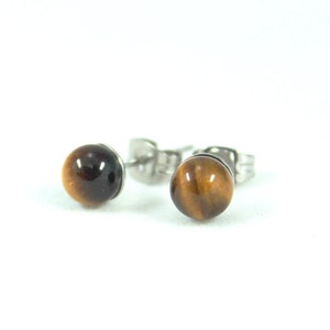 May include: A pair of gold-toned stud earrings with round tiger's eye stones.