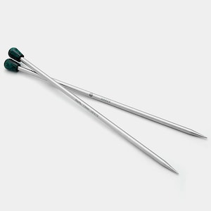 May include: A pair of silver knitting needles with green plastic tips. The needles are 7.0 mm (US size 10) and are 125 cm (49.2 inches) long. The needles are labelled "GRACE" and "Addi Novel" on the shaft.