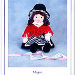 May include: A knitted doll wearing a red and black dress, a black hat, and a red shawl. The doll is sitting on a blue background with a white ribbon.