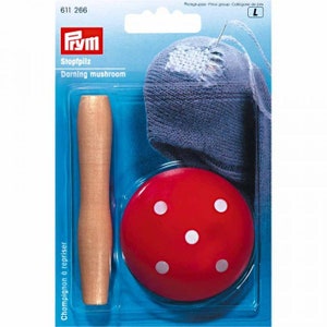 May include: A darning mushroom kit, comprising a red mushroom-shaped tool with white spots, a wooden handle, and a blue sock with a needle and thread. The package includes the text "Stopfpilz Darning mushroom".