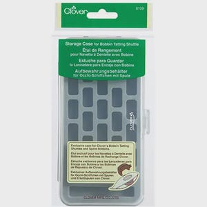 以下が含まれることがあります： Cloverのボビンタティングシャトルとスペアボビンのための透明なプラスチック製の収納ケース。ケース内はグレーで、格子模様があります。緑と白のヘッダーには、Cloverのロゴと製品情報が表示されています。