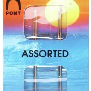 Peut inclure: Un paquet d'aiguilles à laine assorties. L'emballage est principalement bleu et orange, avec le texte "WOOL NEEDLES" et "ASSORTED". La marque "PONY" est visible. Le paquet comprend également du texte en plusieurs langues.