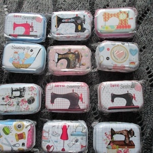 May include: A selection of rectangular metal tins, each decorated with sewing-related imagery. The tins display sewing machines, thread spools, and other sewing accessories. Some tins are labelled with the words "love Sewing".