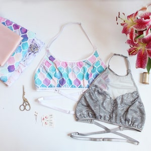May include: Two halter tops, one with a blue and purple geometric pattern and the other with a gray lace overlay. Both tops have adjustable straps and are made of soft, comfortable fabric.