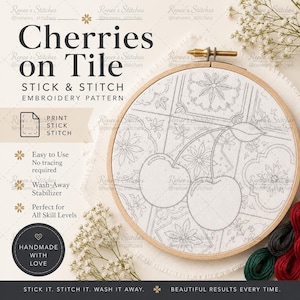 May include: A round wooden embroidery hoop containing white fabric with a printed pattern of two cherries and floral tile motifs. The text reads Cherries on Tile, Stick & Stitch Embroidery Pattern, Print Stick Stitch, Easy to Use, Wash-Away Stabilizer.