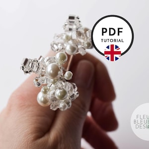 Peut inclure: Un accessoire de coiffure perl&eacute; compos&eacute; de grappes de fausses perles blanches et de cristaux transparents &agrave; facettes sur une structure en fil m&eacute;tallique. Un graphique circulaire avec le texte PDF TUTORIAL et un drapeau britannique est pr&eacute;sent.