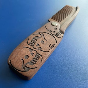 Wooden flick comb featuring one of two designs by the great Mr. Heggie.