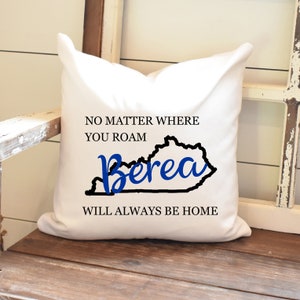 May include: White throw pillow with black text that reads "No matter where you roam Berea will always be home". The text is centered on the pillow with a black outline of the state of Kentucky and the word Berea in blue cursive.