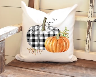 May include: White pillow with a black and white checkered pumpkin and an orange pumpkin with green leaves. The pumpkins are watercolor illustrations.