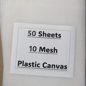 May include: A stack of 50 white plastic canvas sheets with a 10 mesh count. The sheets are packaged with a white label that reads "50 Sheets 10 Mesh Plastic Canvas".