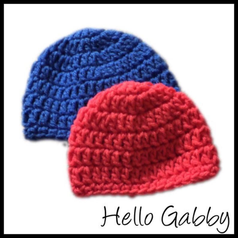 May include: Two crocheted hats, one red and one blue. The hats are made with a simple stitch pattern and have a rounded crown.