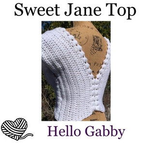 May include: White crochet top with a deep V-neck and a scalloped edge. The top is shown on a mannequin and has a "Sweet Jane Top" and "Hello Gabby" text overlay.