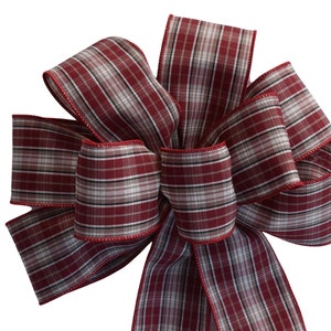 May include: A red and white plaid bow with a red edge. The bow is made of a soft, silky fabric.