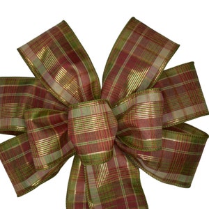 May include: A plaid bow with red, green and gold accents. The bow is made of a sheer fabric with a metallic sheen.