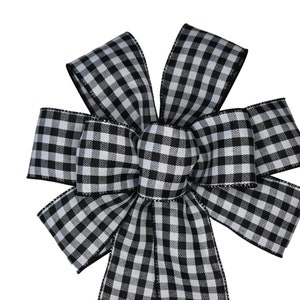 May include: A black and white gingham bow with a center loop. The bow is made of a soft, textured fabric.