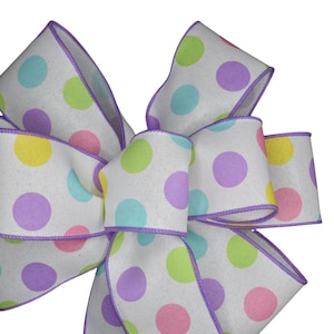 May include: A white bow with a purple trim and pastel polka dots in yellow, pink, and blue.