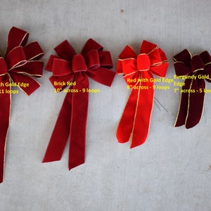 Può includere: Cinque fiocchi di velluto di diverse dimensioni e colori, tra cui rosso mattone, rosso con bordo dorato e oro bordò. I fiocchi misurano 30,5 cm, 25,4 cm, 20,3 cm, 17,8 cm e 15,2 cm di larghezza.