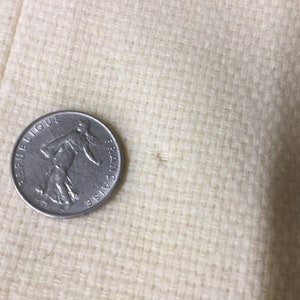 May include: A silver French coin with the words "Republique Francaise" inscribed around the edge.